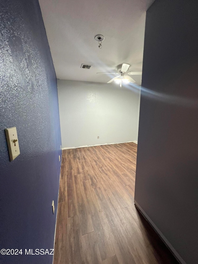 empty room with ceiling fan and wood-type flooring