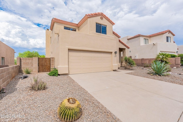 view of front facade with a gate, fence, driveway, stucco siding, and a garage