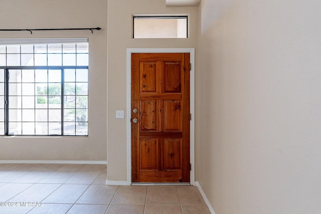 entrance foyer featuring light tile patterned floors, baseboards, and a wealth of natural light