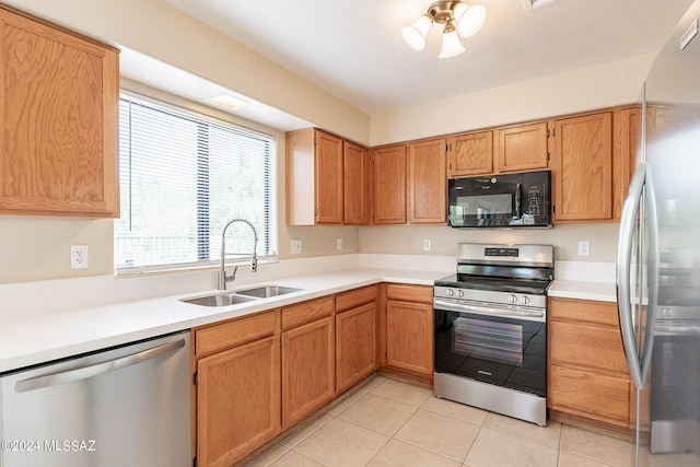 kitchen featuring light tile patterned flooring, stainless steel appliances, light countertops, and a sink