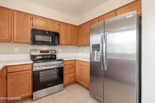 kitchen featuring light tile patterned floors, stainless steel appliances, and light countertops