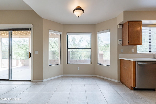 unfurnished dining area with light tile patterned flooring, baseboards, and a wealth of natural light