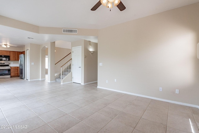 unfurnished living room featuring visible vents, stairway, arched walkways, light tile patterned floors, and baseboards