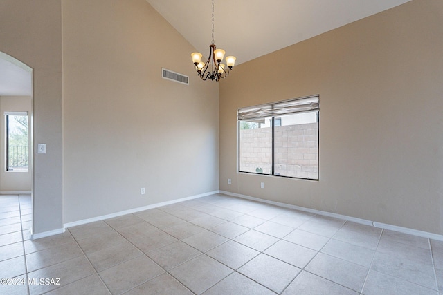 spare room featuring light tile patterned floors, visible vents, arched walkways, and a wealth of natural light