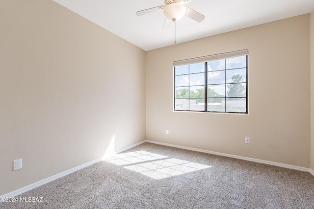 carpeted empty room featuring baseboards and a ceiling fan