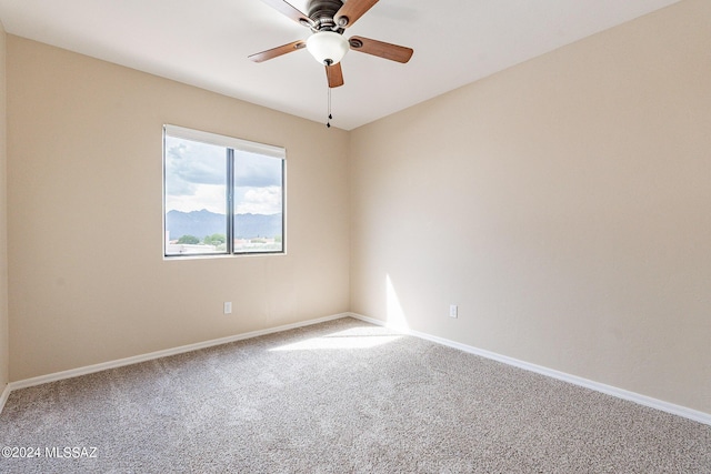 carpeted empty room featuring baseboards and ceiling fan