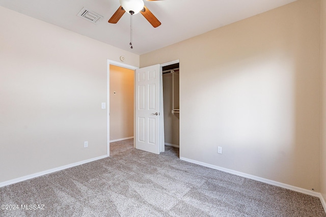 carpeted empty room with visible vents, a ceiling fan, and baseboards