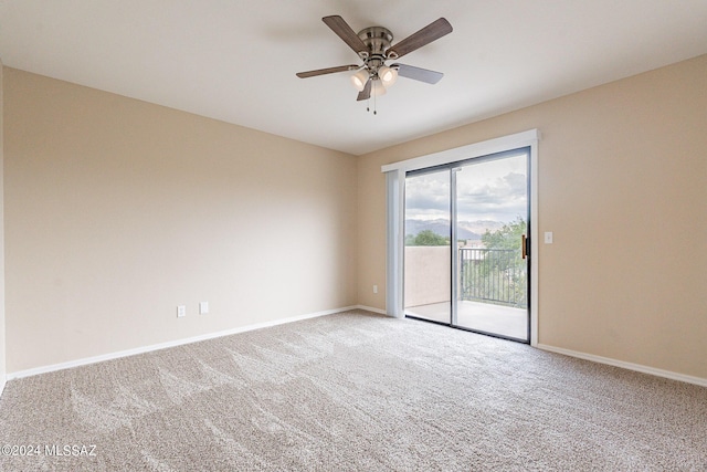 carpeted empty room featuring baseboards and ceiling fan