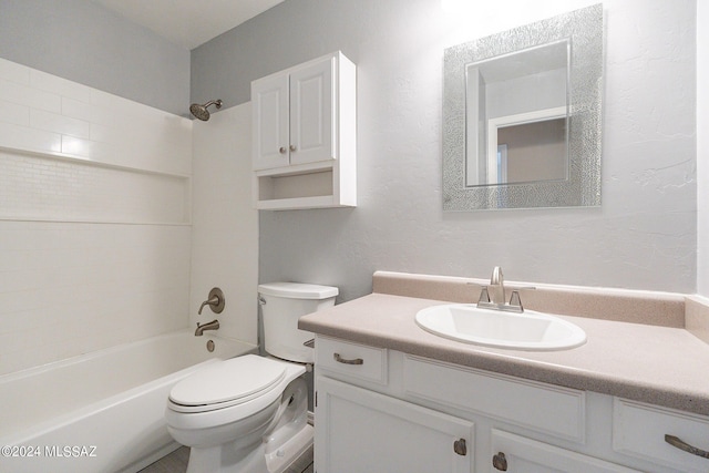 full bathroom featuring toilet, vanity, a textured wall, and washtub / shower combination