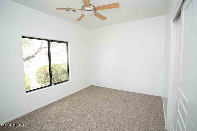 unfurnished room with plenty of natural light, carpet flooring, and ceiling fan