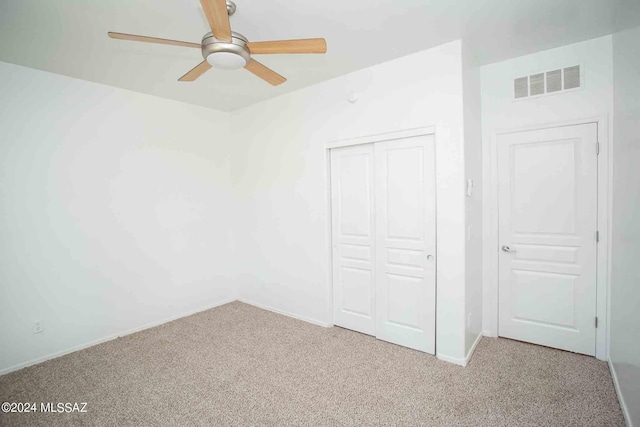 unfurnished bedroom featuring light colored carpet, a closet, and ceiling fan