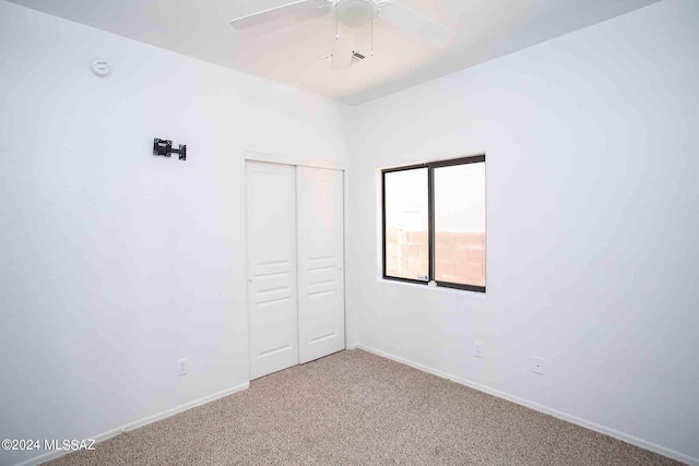 unfurnished bedroom featuring a closet, ceiling fan, and carpet