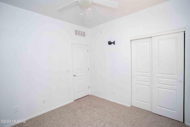 unfurnished bedroom with light carpet, a closet, and ceiling fan