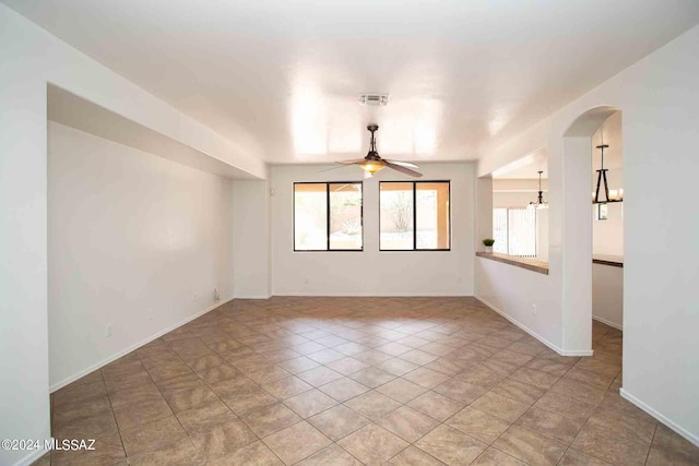 unfurnished room with ceiling fan with notable chandelier