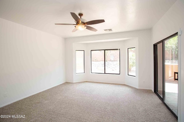 spare room featuring light colored carpet and ceiling fan