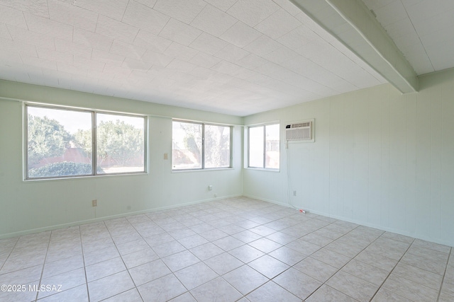 unfurnished room featuring beam ceiling and a wall mounted AC