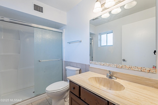 bathroom featuring vanity, tile patterned floors, a shower with door, and toilet