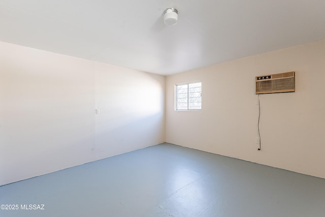 unfurnished room with an AC wall unit and concrete floors