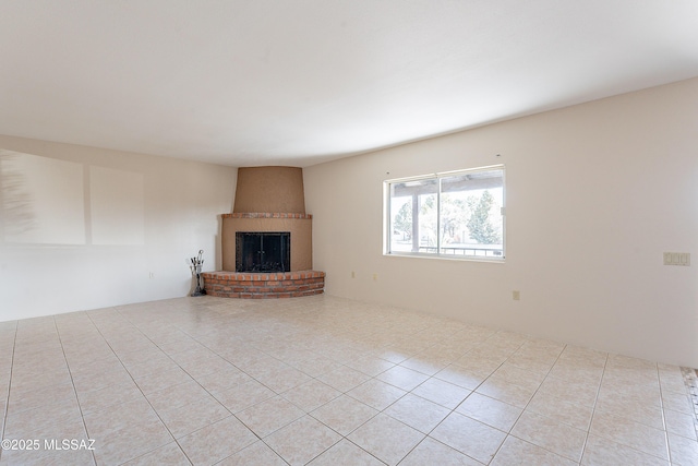 unfurnished living room featuring a fireplace and light tile patterned floors