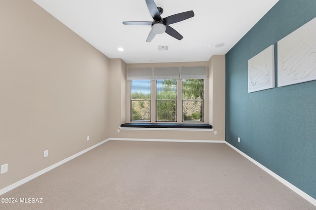 carpeted spare room featuring ceiling fan