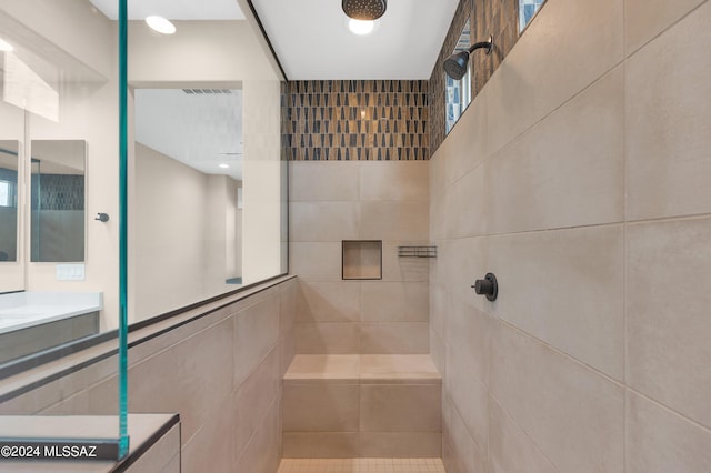 bathroom featuring tile walls, vanity, and tiled shower