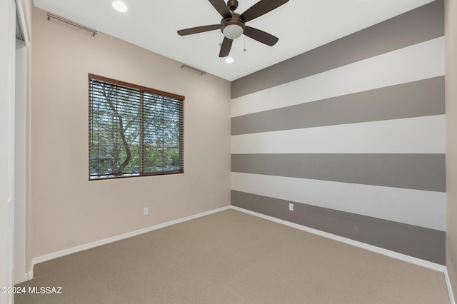 carpeted spare room with ceiling fan