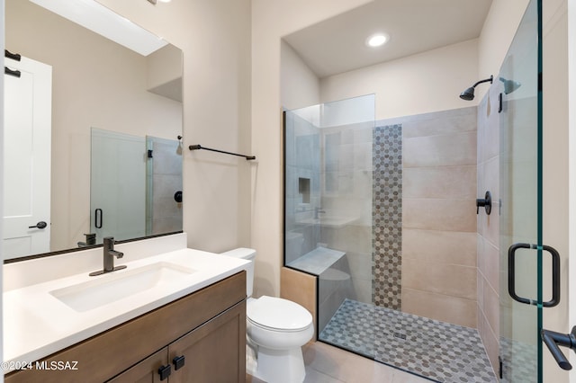 bathroom with walk in shower, vanity, and toilet