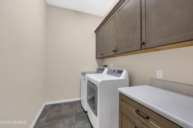 clothes washing area with washer and clothes dryer and cabinets