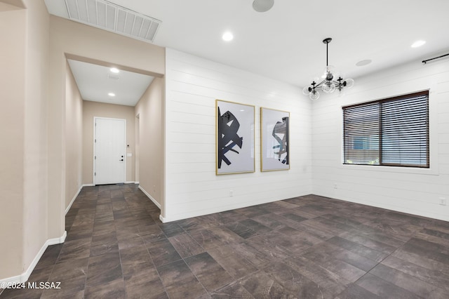 interior space featuring a notable chandelier and wooden walls