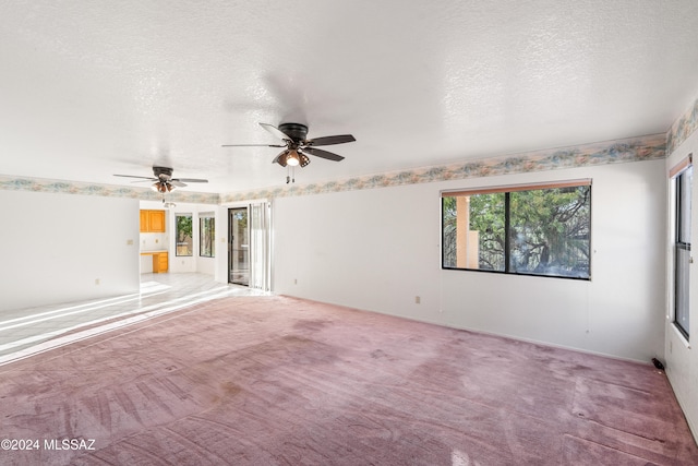 carpeted spare room featuring a textured ceiling and ceiling fan