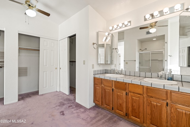 bathroom featuring ceiling fan, walk in shower, and vanity