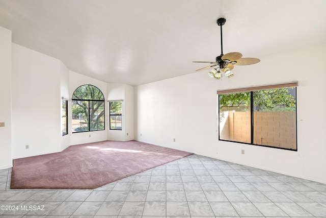 carpeted spare room featuring ceiling fan and vaulted ceiling