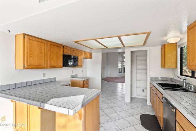 kitchen featuring kitchen peninsula, tile countertops, sink, stainless steel dishwasher, and light tile patterned flooring