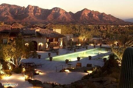 snow covered pool with a mountain view and a patio