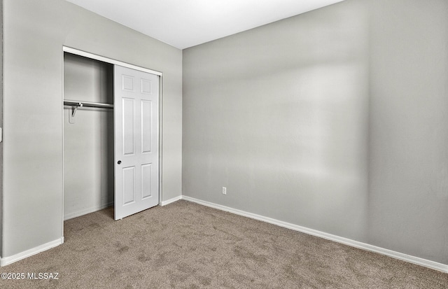 unfurnished bedroom featuring carpet floors and a closet