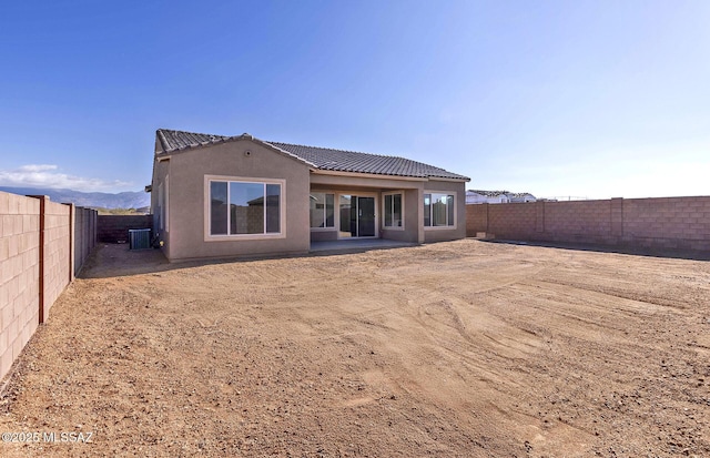 rear view of property with cooling unit and a mountain view