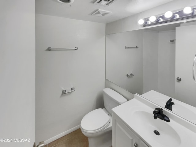 bathroom featuring tile patterned floors, vanity, and toilet