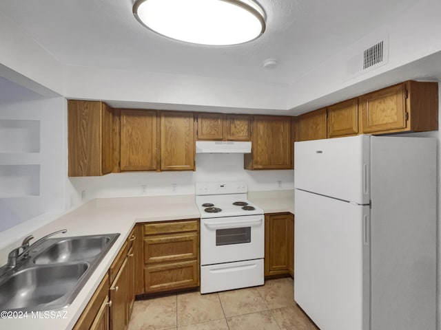 kitchen featuring light tile patterned floors, white appliances, and sink