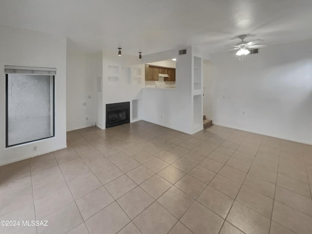 unfurnished living room featuring ceiling fan and light tile patterned flooring