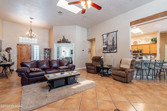 living room featuring visible vents, a towering ceiling, and light tile patterned floors