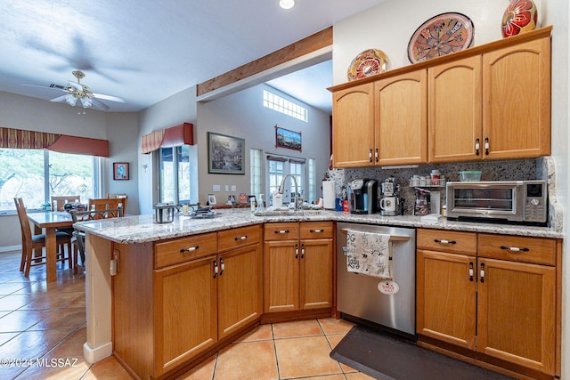 kitchen with light tile patterned flooring, a peninsula, a sink, a healthy amount of sunlight, and stainless steel dishwasher