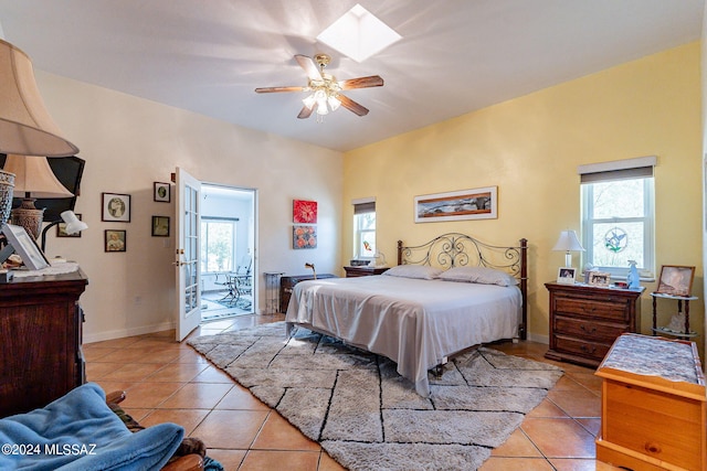 bedroom with a skylight, multiple windows, baseboards, and light tile patterned floors