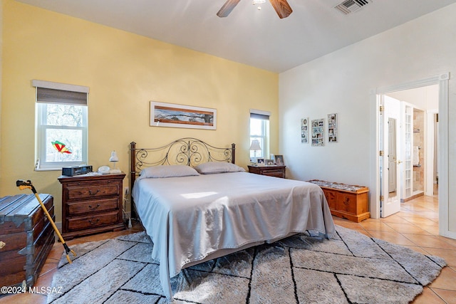 bedroom featuring light tile patterned flooring, visible vents, and a ceiling fan