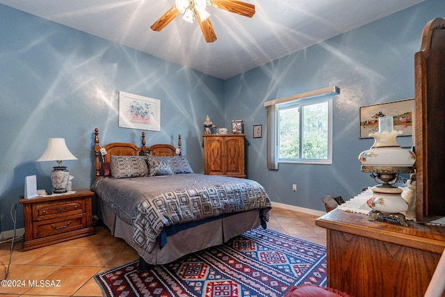 bedroom with a ceiling fan, baseboards, and light tile patterned floors