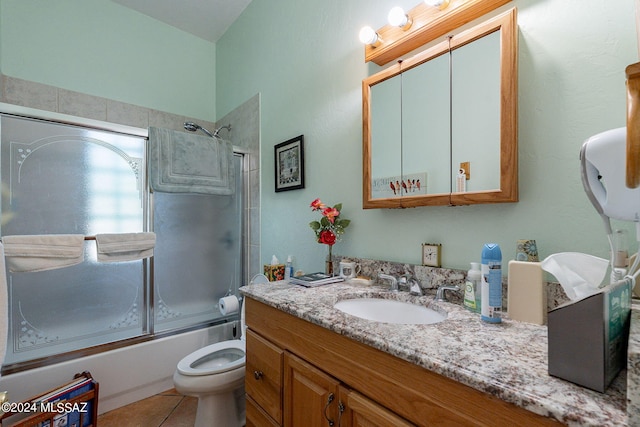 full bath featuring tile patterned flooring, enclosed tub / shower combo, vanity, and toilet