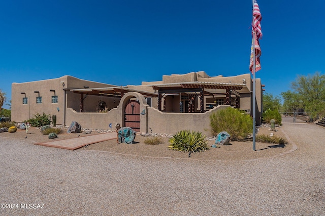 adobe home with a fenced front yard