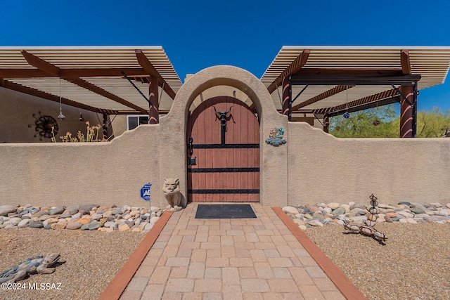 view of gate with fence and a pergola