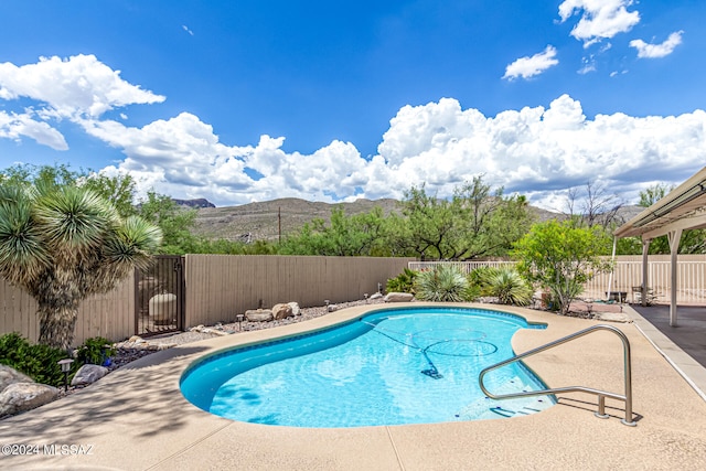 view of swimming pool featuring a mountain view and a patio area