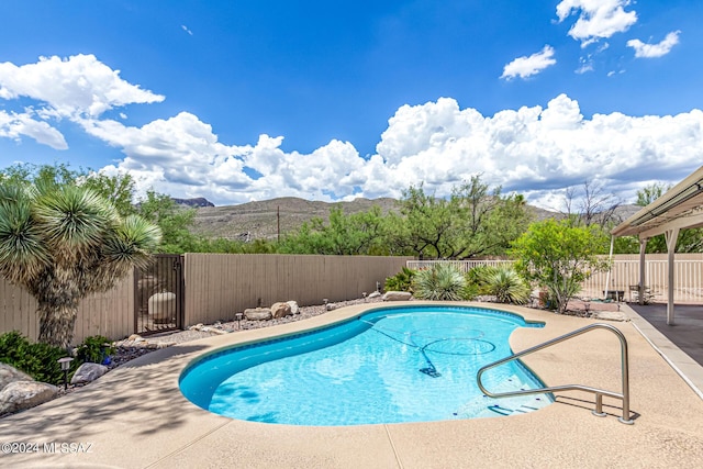 view of pool featuring a mountain view, a patio, a fenced backyard, and a fenced in pool