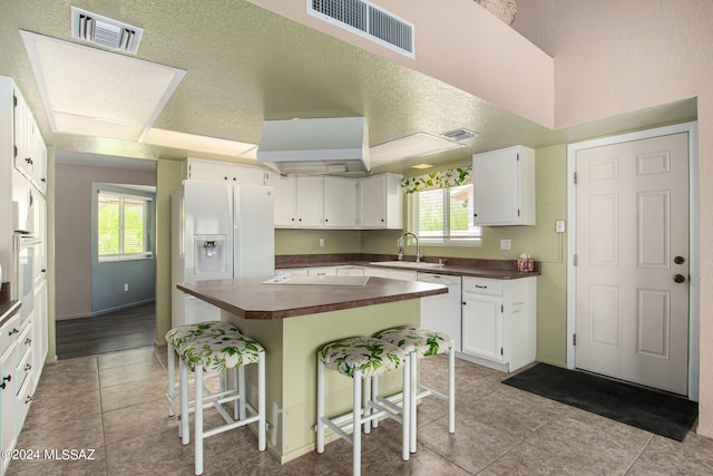 kitchen featuring a breakfast bar area, plenty of natural light, and light tile patterned flooring